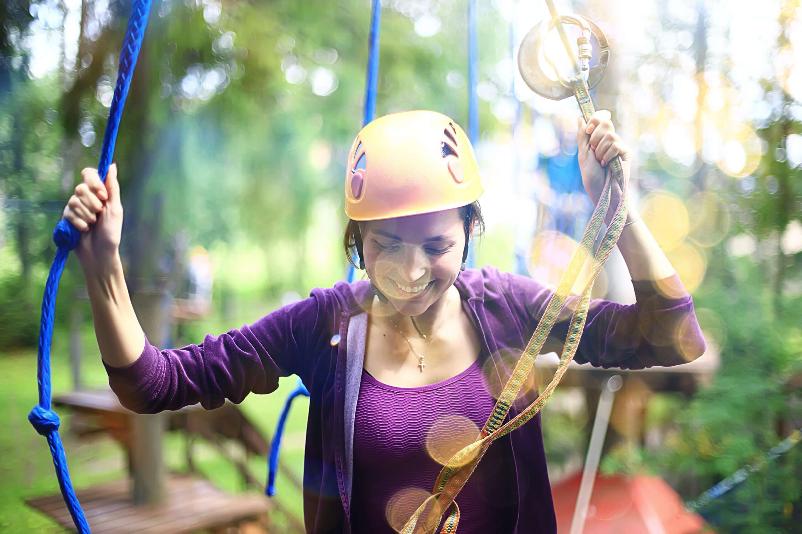 Happy woman walking through ropes course